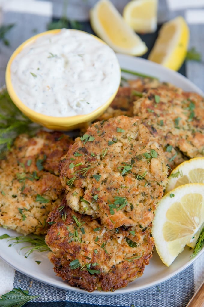 close up of salmon patties on a plate with homemade tartar sauce and lemon wedges | salmon patty recipe | salmon cakes