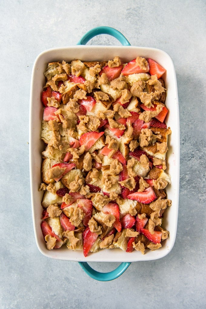 An overhead image of a baked french toast casserole with strawberries on top
