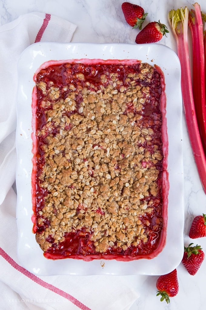 Strawberry Rhubarb Crisp in a white ruffled baking dish