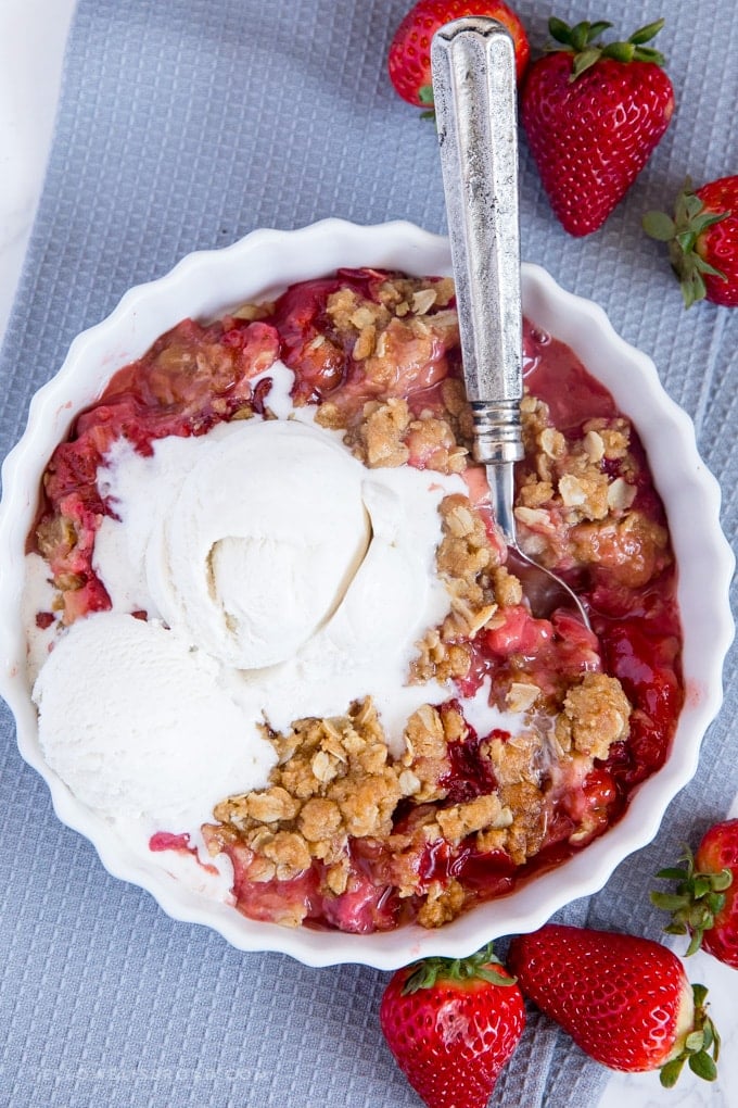 A serving of Strawberry Rhubarb Crisp with vanilla ice cream