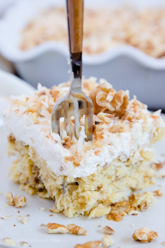 a fork in a slice of walnut pineapple cake