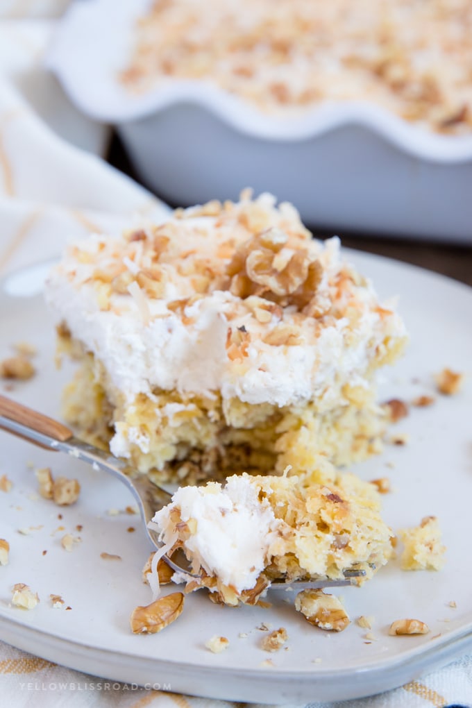 a bite taken out of a slice of walnut pineapple cake