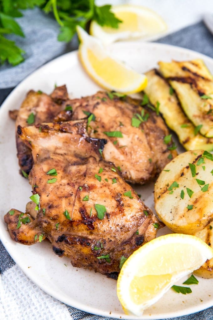 grilled chicken marinade recipe - grilled chicken thighs, potatoes and lemon on a plate.