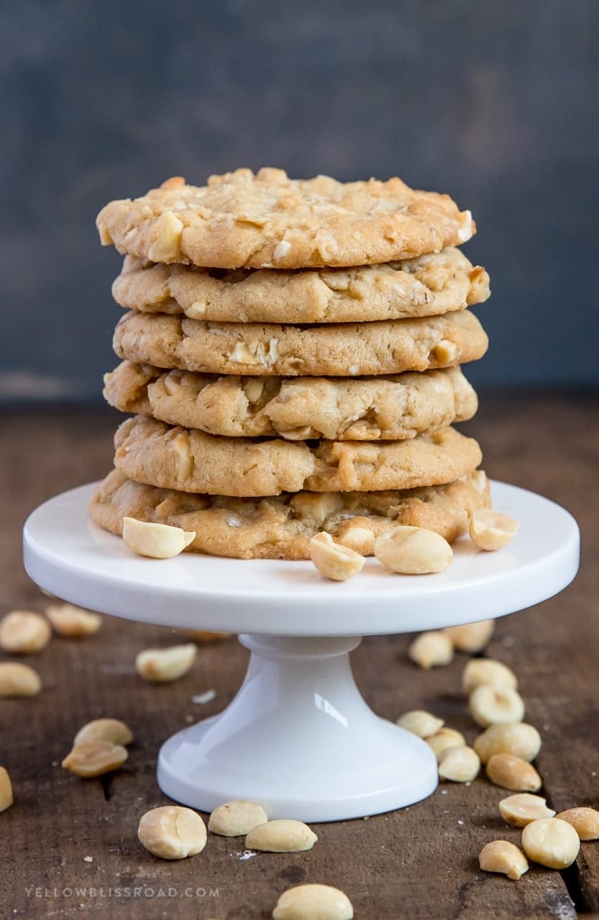 A stack of oatmeal peanut butter cookies on a small plate with peanuts scattered around.