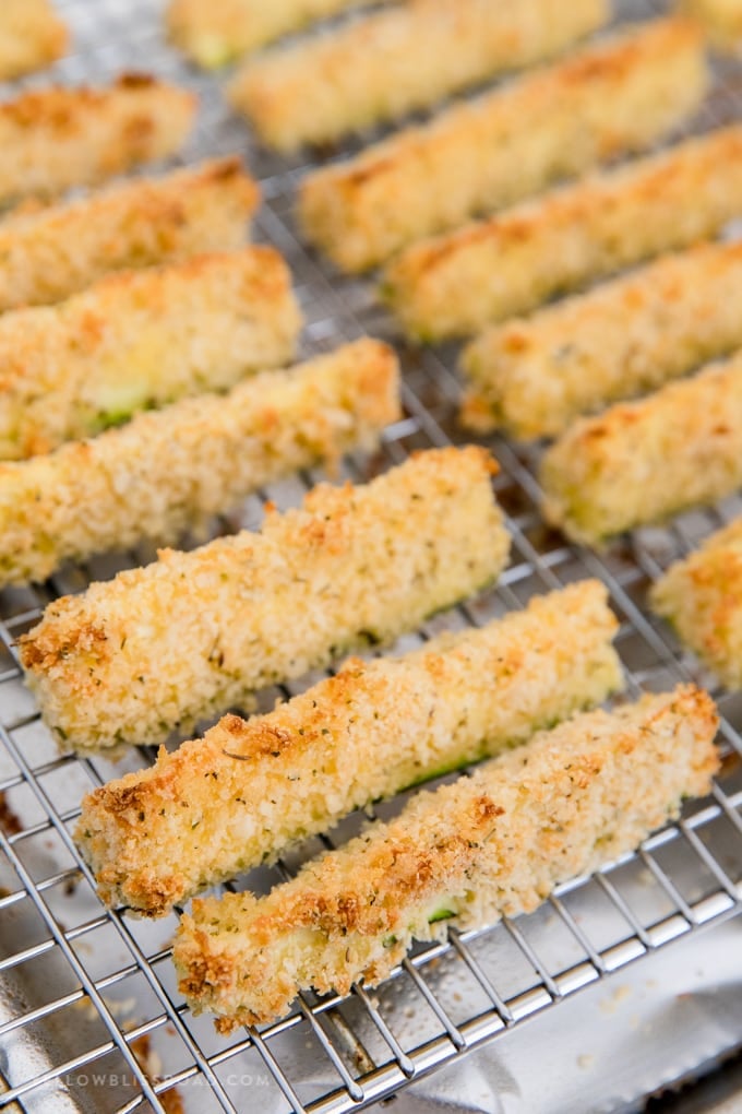 baked zucchini fries on a metal cooling rack.
