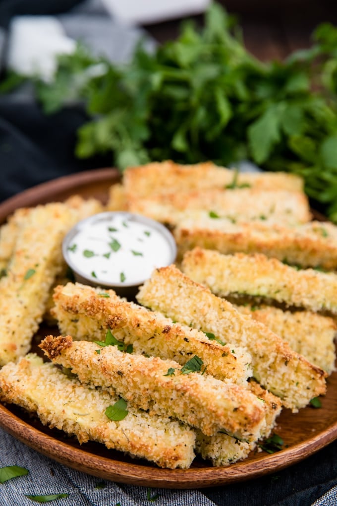baked zucchini fries with a side of ranch dressing.