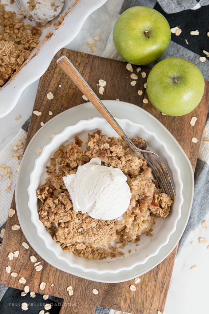 This Apple Crumble recipe is a no-fuss rustic dessert with a cinnamon-laced crumbly oat topping that everyone will enjoy. apple crumble with ice cream