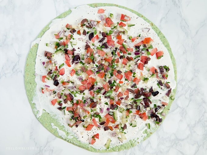 Greek Salad Pinwheels - Spinach tortilla topped with Greek yogurt, feta cheese and veggies