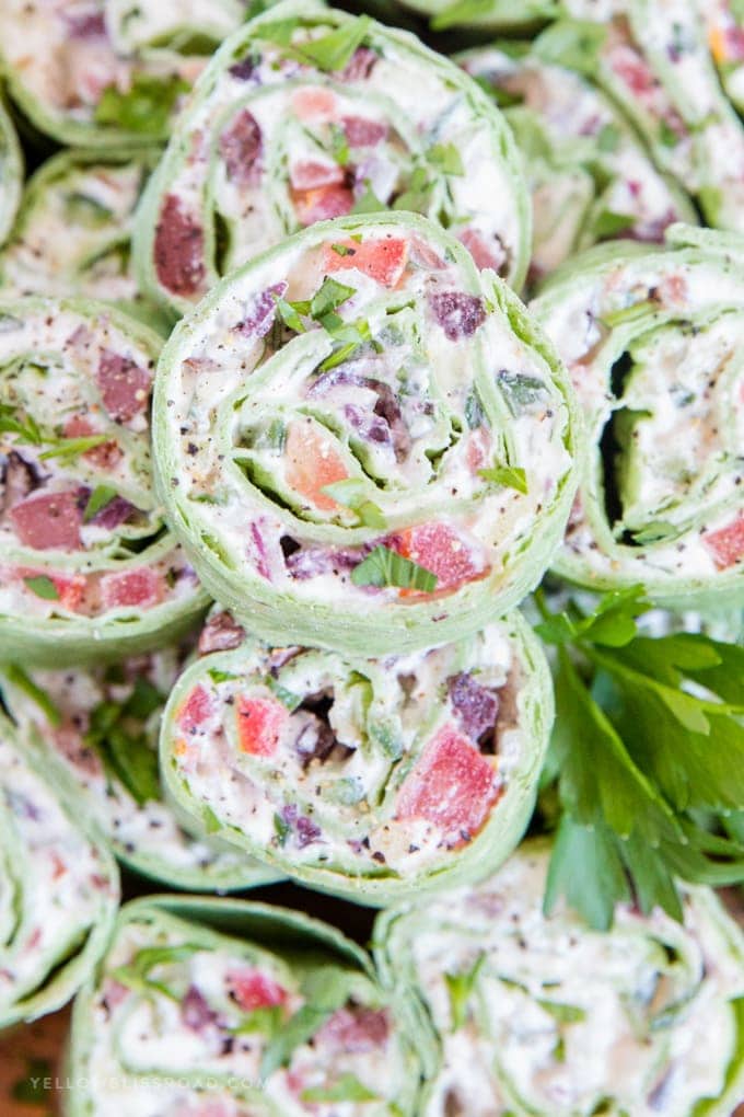 These Creamy Greek Salad Pinwheels are a delicious appetizer made with tangy Feta cheese, Kalamata olives, crunchy cucumbers, juicy tomatoes and oregano.
