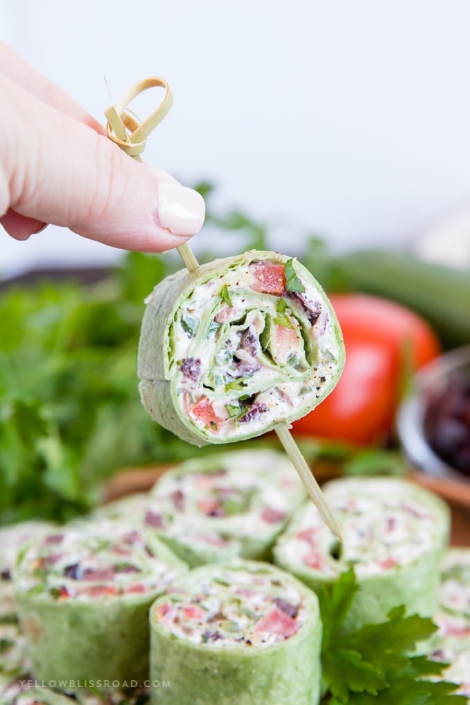 Greek salad pinwheel appetizer stuck with a toothpick.