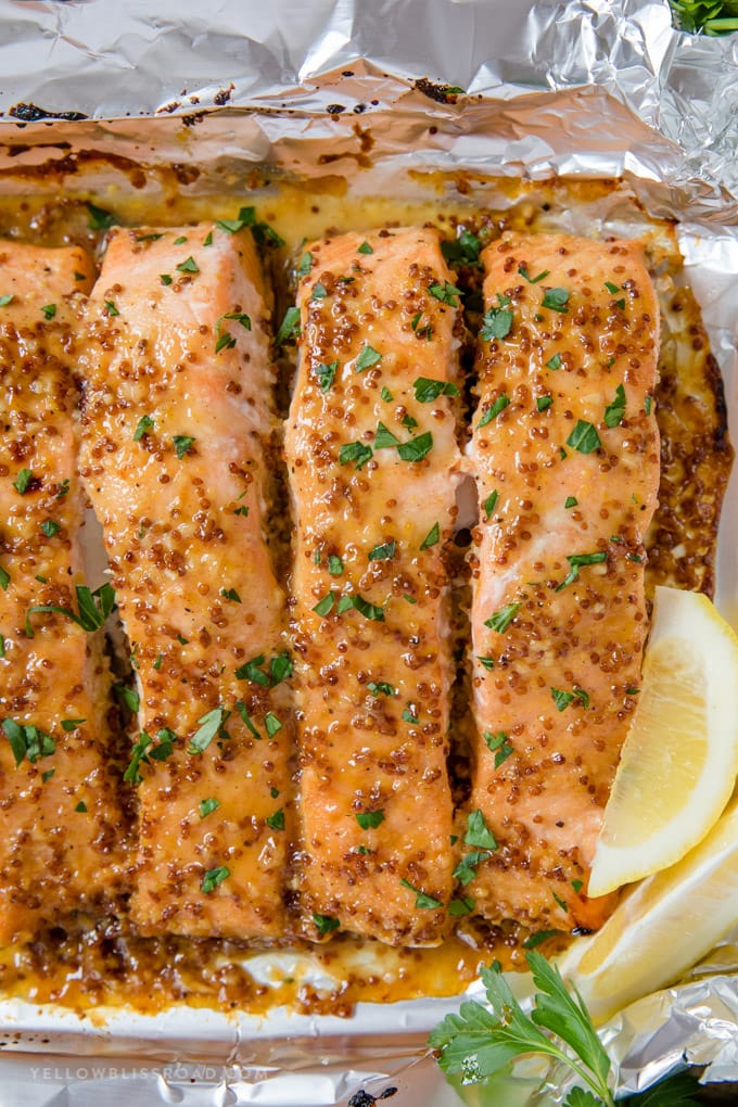 Honey Mustard Salmon is an easy dinner recipe that the whole family will love. Tender, flaky salmon filet with a rich honey and whole grain mustard glaze. #dinner #recipe salmon filets with honey mustard glaze