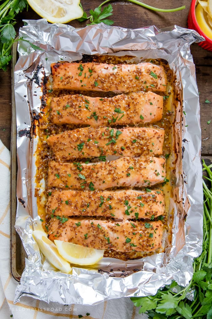 Honey Mustard Salmon is an easy dinner recipe that the whole family will love. Tender, flaky salmon filet with a rich honey and whole grain mustard glaze. #dinner #recipe Baked Honey Mustard Salmon recipe
