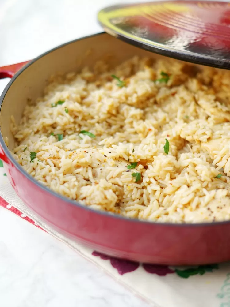 lid being taken off skillet for Skillet Garlic Chicken and Rice Casserole