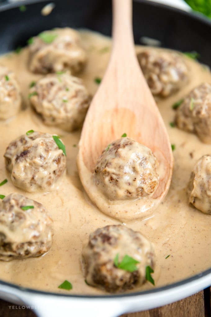 Swedish meatballs in a pan with a wooden spoon