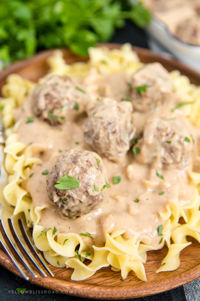 Swedish Meatballs are tender meatballs made with ground beef and ground pork smothered in a sour cream gravy and served over mashed potatoes or noodles. Swedish Meatball recipe