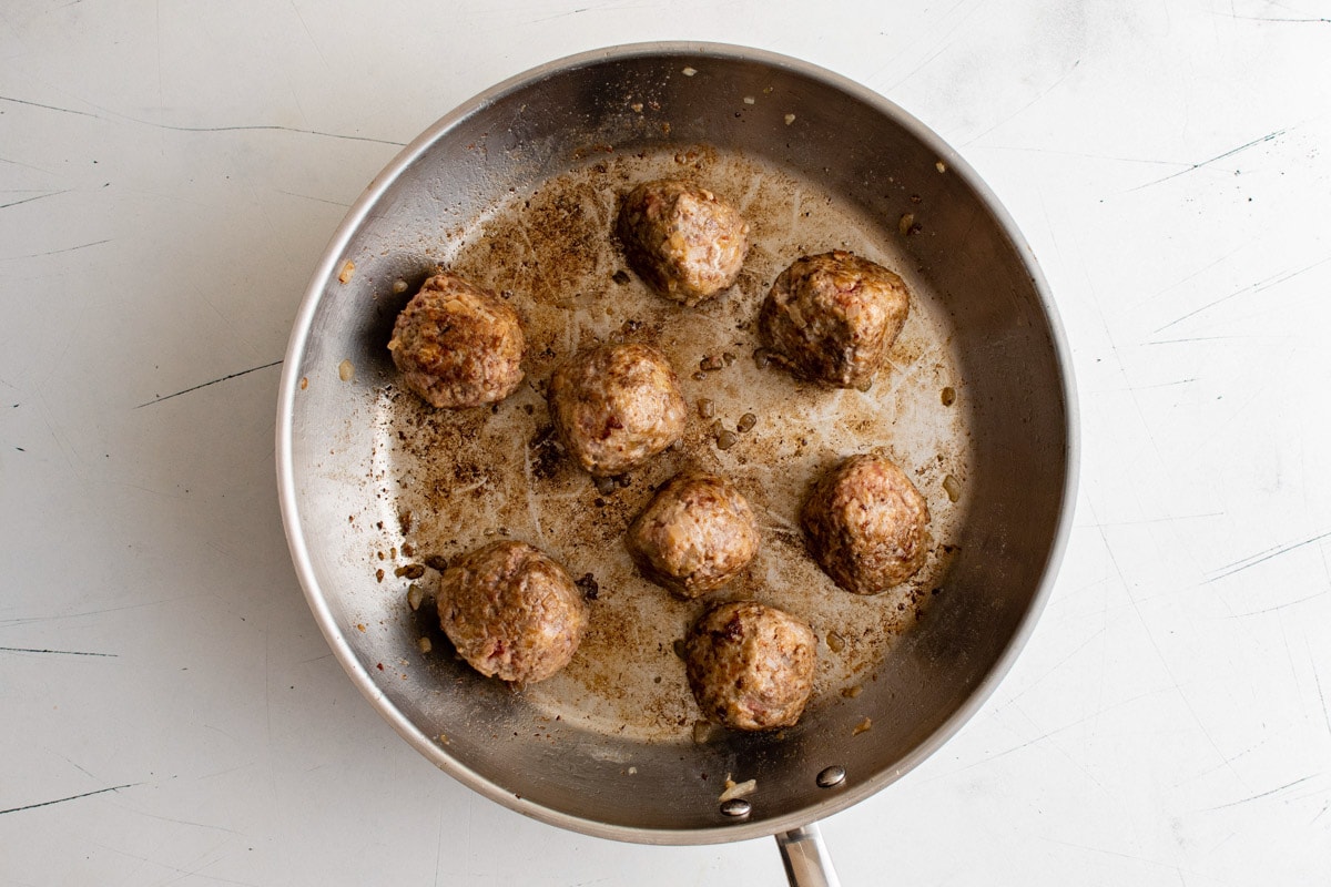 Browned meatballs in a large skillet.