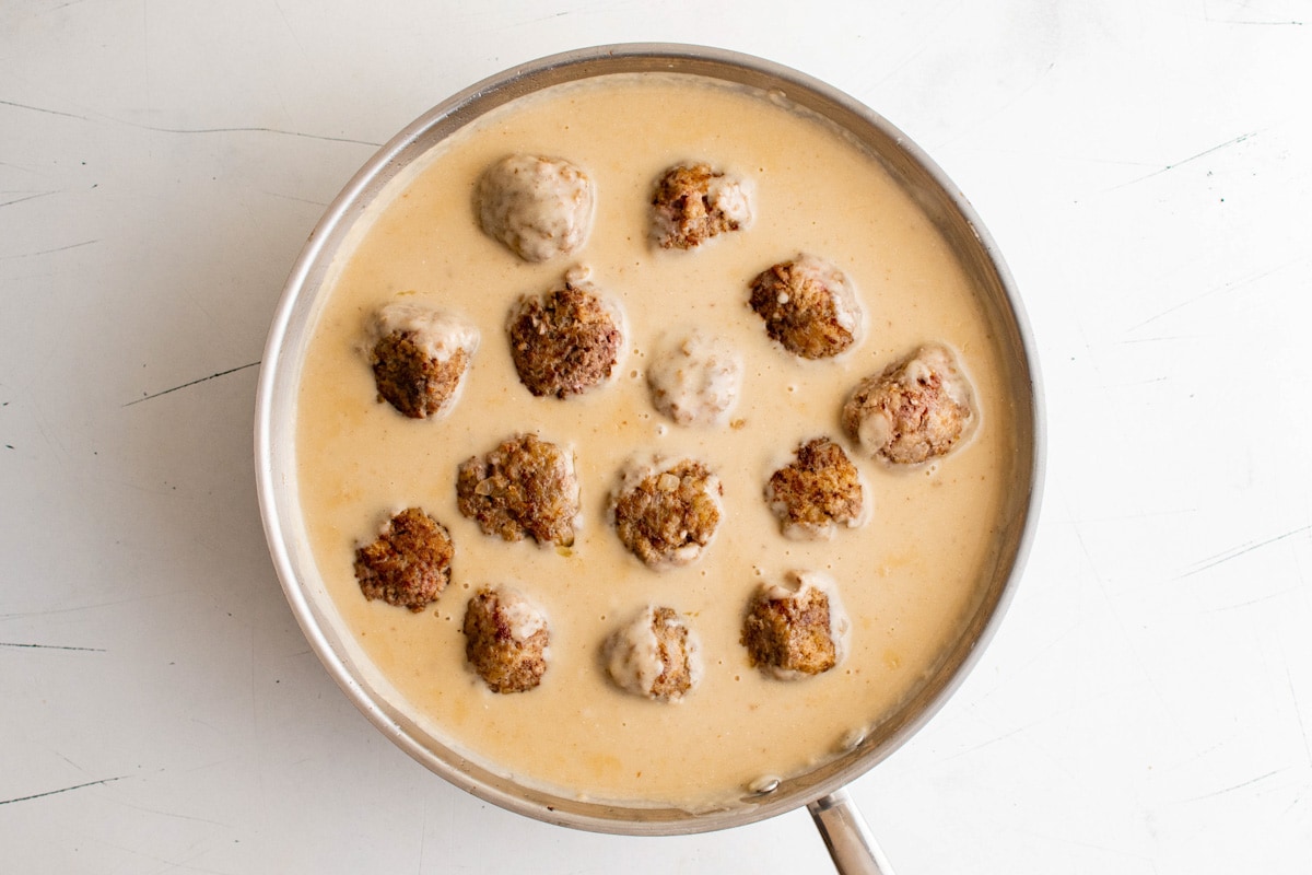 Browned meatballs sitting in a sour cream gravy.