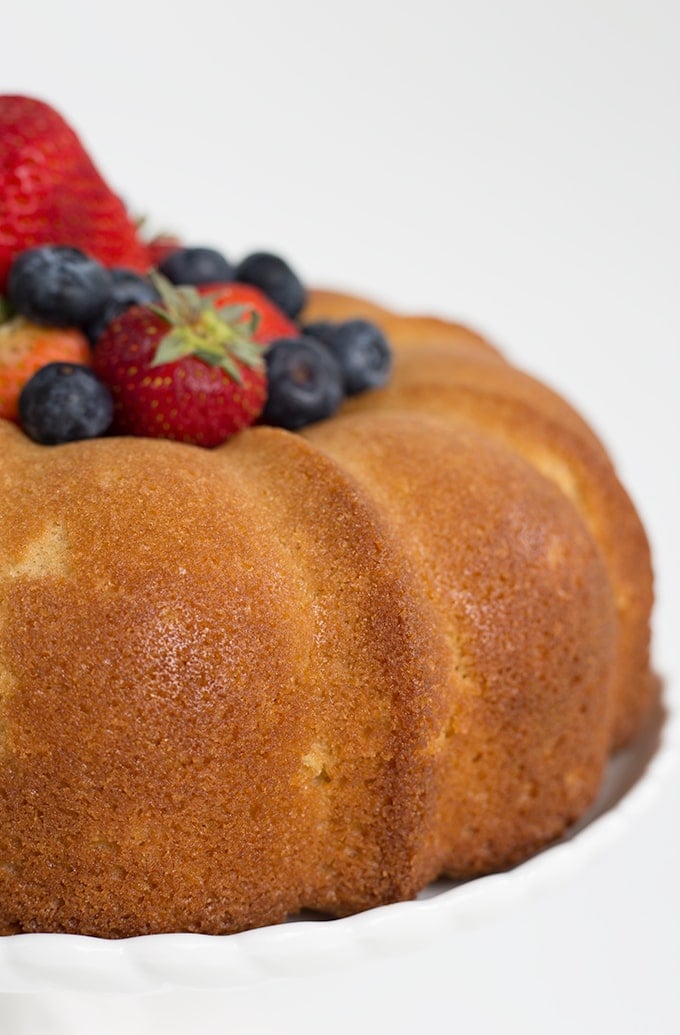 This soft, buttery pound cake is perfect by itself or topped with fresh fruit. It bakes up great in a bundt pan or loaf pan too! pound cake recipe made in a bundt pan and topped with fresh berries