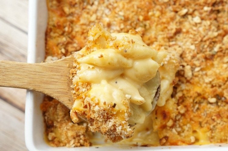 Wooden spoon with a serving of baked mac and cheese.