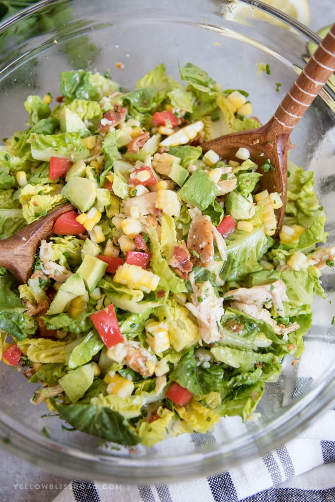Bacon Avocado Chicken Salad with Lemon Vinaigrette tossed in a bowl with the healthy salad dressing.