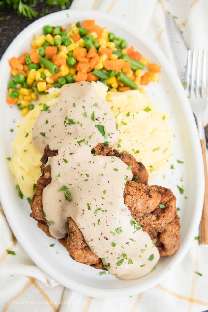 This Chicken Fried Steak Recipe is made with lightly breaded and fried cube steak and a creamy homemade gravy. Perfect for breakfast or dinner. chicken fried steak recipe with homemade gravy
