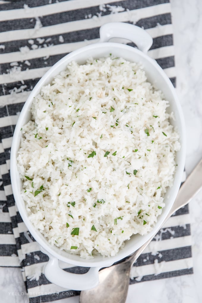 Coconut rice in a white dish sitting on a black and white towel.