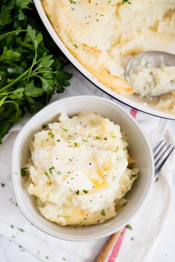 Fluffy, creamy and so flavorful this Make Ahead Mashed Potatoes recipe is a simple and easy side dish that will be the star of any meal. bowl of potatoes that have been mashed with butter and parsley