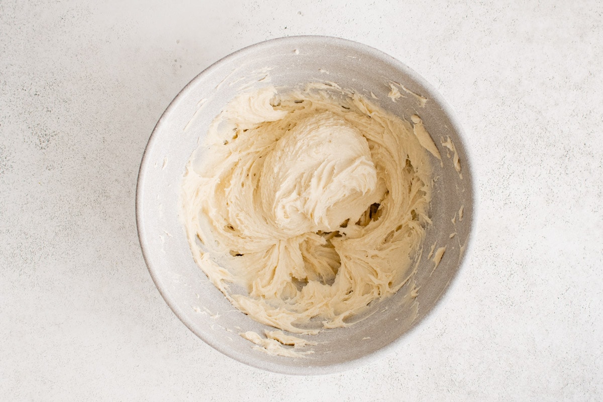 Cream cheese, sugar and flour, mixed together in a bowl.