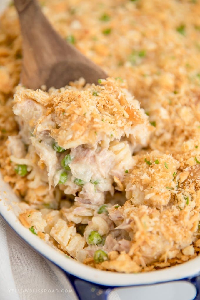 My Tuna Casserole Recipe is pure, classic comfort food for a weeknight dinner. Tuna, noodles and peas in a cheesy homemade sauce with a crunchy cracker crumb topping. a close up image of Tuna Casserole on a spoon.
