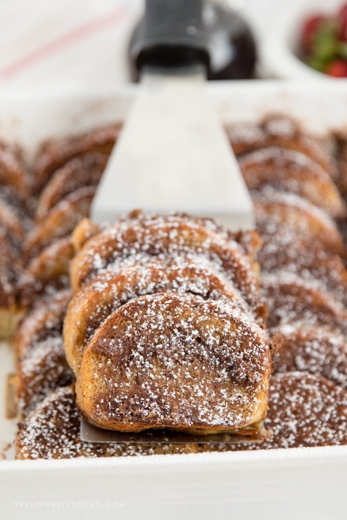 Sliced of overnight baked french toast on a spatula.