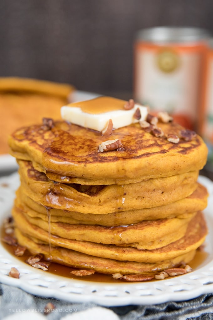 a stack of pumpkin pancakes with butter and syrup.