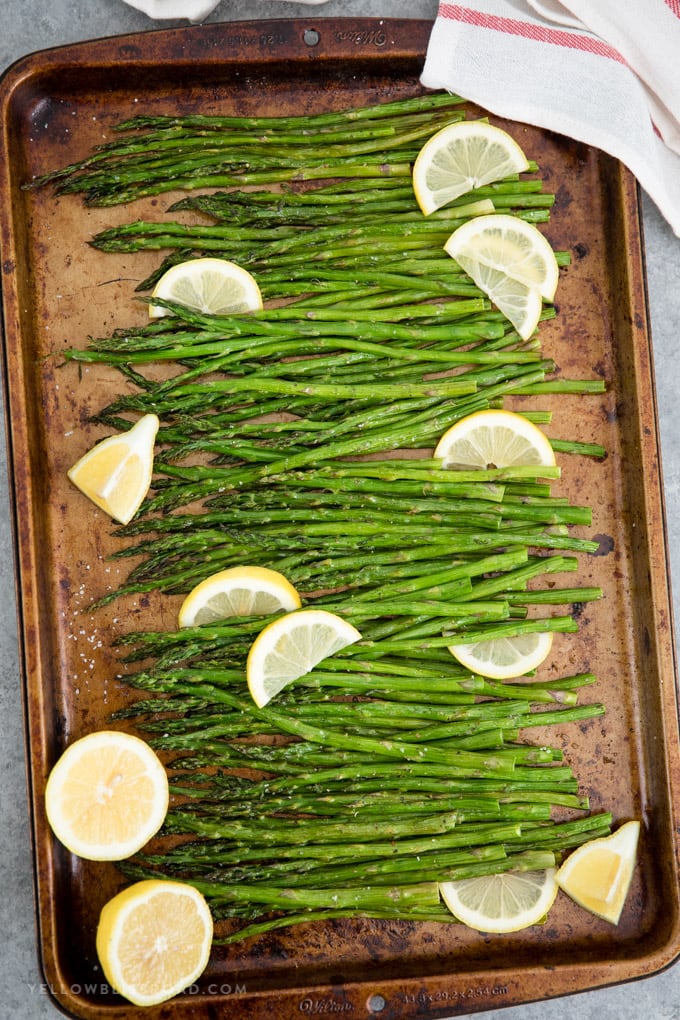 Easy oven roasted asparagus on a large baking sheet with lemon slices