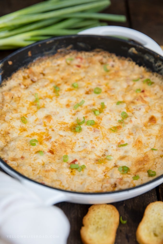 Baked shrimp dip in a white cast iron skillet.