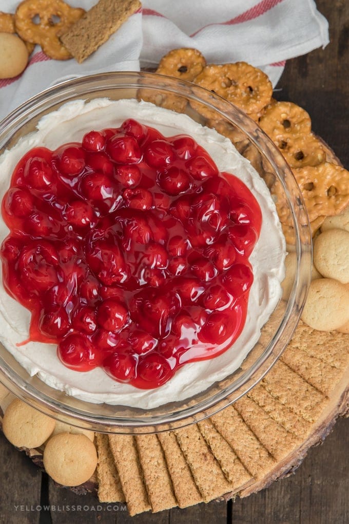 No Bake Cherry Cheesecake Dip is a yummy dessert for any occasion. Made with a sweet cream cheese base and cherry pie topping. Cherry Cheesecake Dip | No Bake Cheesecake surrounded by graham crackers, nilla wafers and pretzels