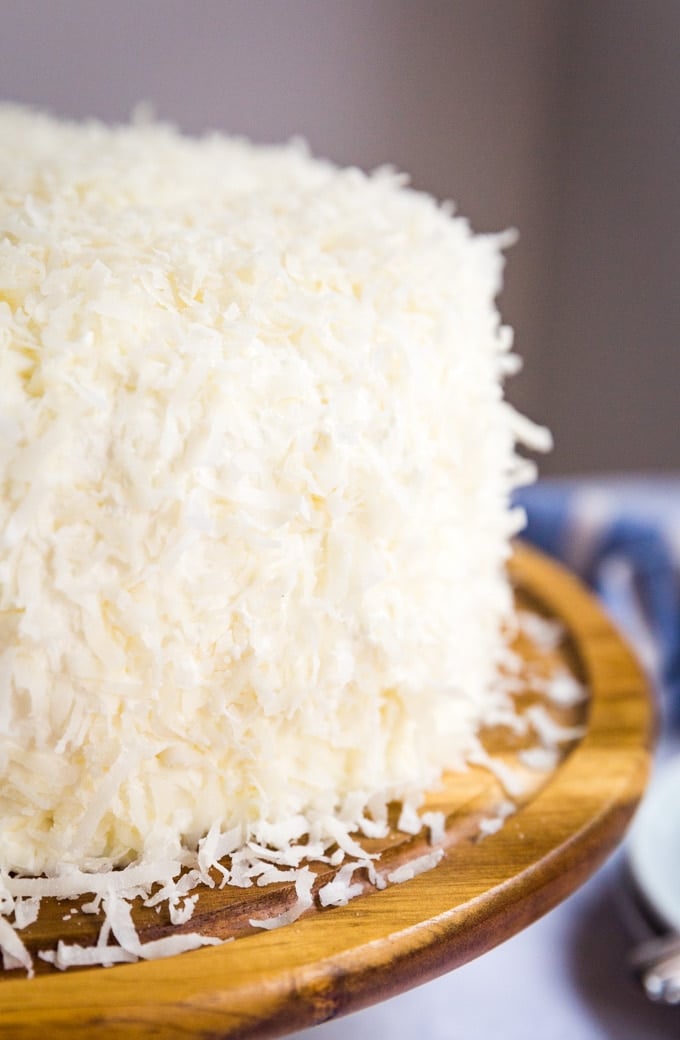 coconut cake with shredded coconut pressed onto the frosting all over the cake