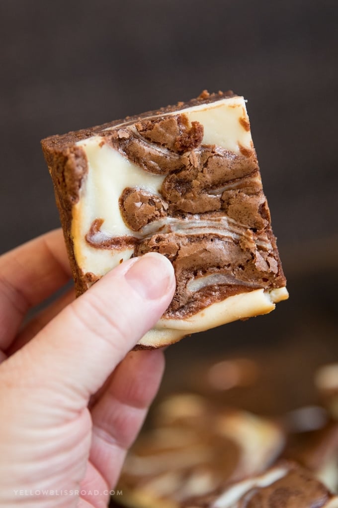A hand holding one Cream Cheese Brownies | Cheesecake Brownies