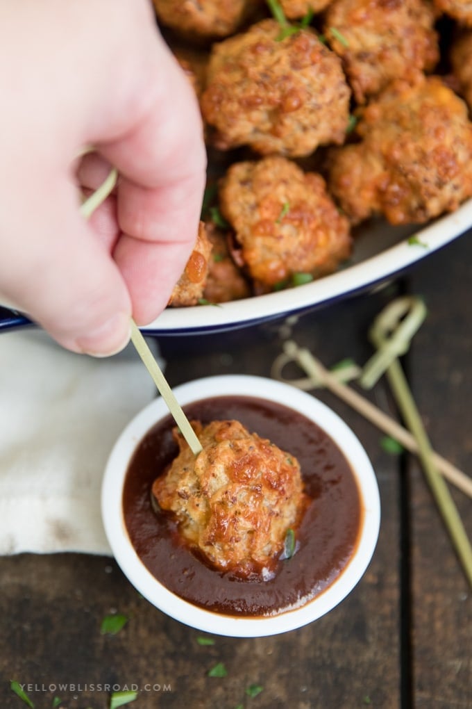 Cream Cheese Sausage Balls (Bisquick Sausage Balls) on a skewer dipped in barbecue sauce.