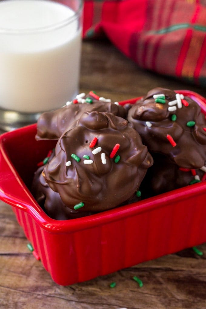 A container of Crockpot candies with a glass of milk. 