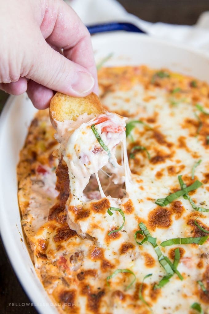 Spicy Italian Sausage Dip with a cheesy pull on a toasted crostini.