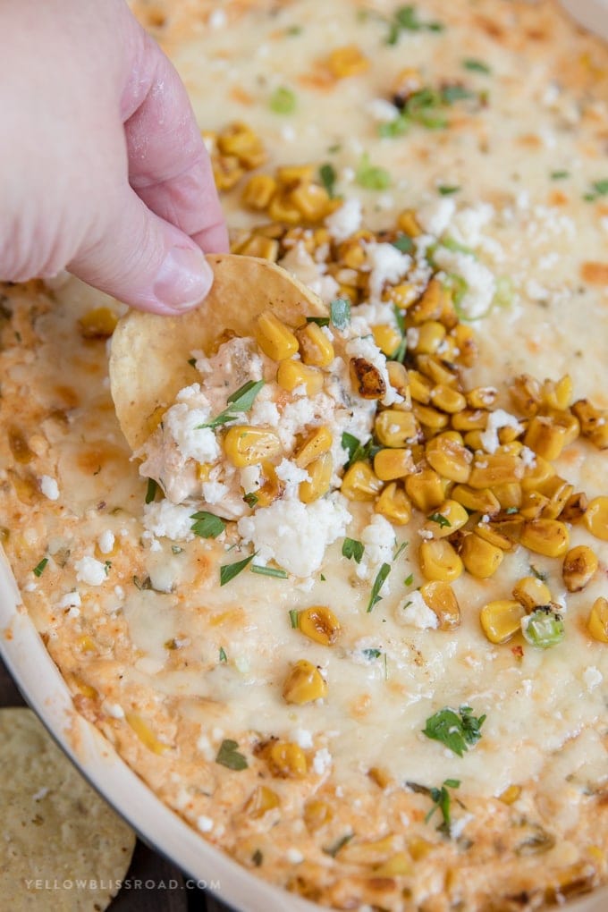 Dipping a tortilla chip into Mexican Corn Dip.