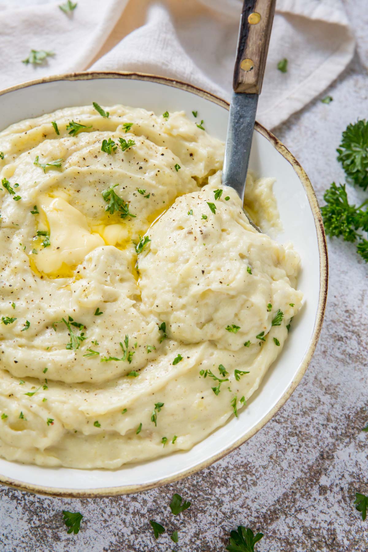 bowl of mashed potatoes, spoon with wooden handle