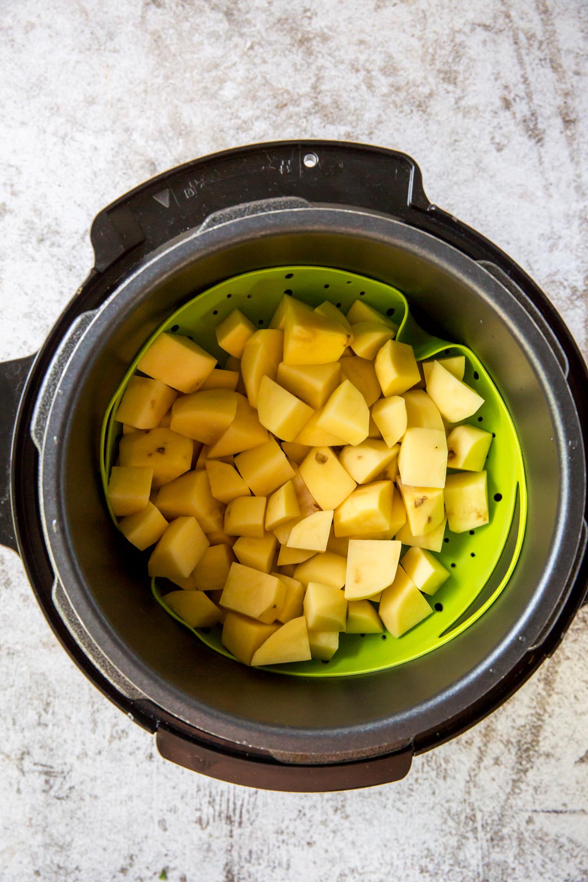 instant pot, chopped potatoes, green silicone basket