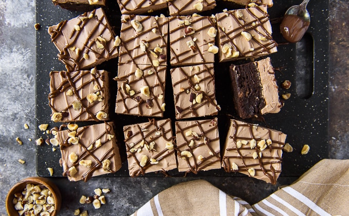 Overhead image of brownies with nutella frosting and hazelnuts.