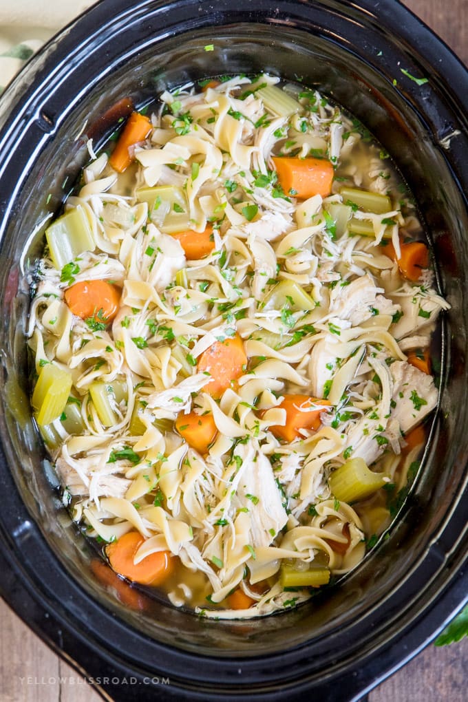 Crock pot filled with chicken noodle soup.