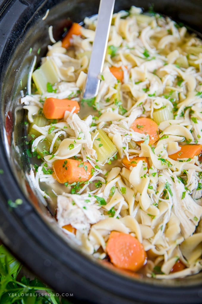 Crockpot Chicken Noodle Soup in the slow cooker with a metal spoon.