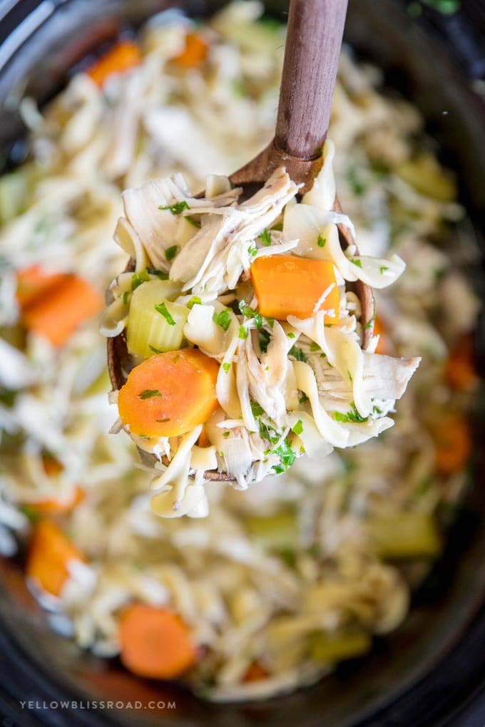 Crockpot Chicken Noodle Soup in a wooden ladle.