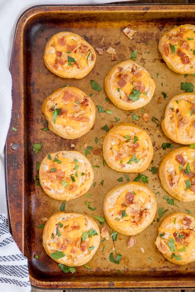 A baking sheet filled with baked crack chicken pinwheels.
