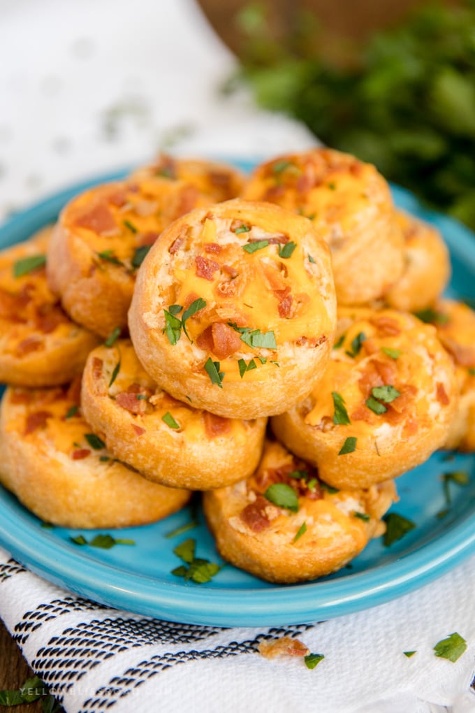 A blue plate stacked with Baked Crack Chicken Pinwheels.