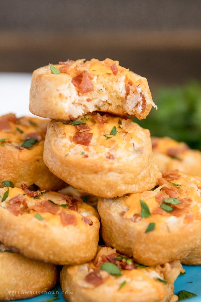 A stack of Baked Crack Chicken Pinwheels with a bite taken out of one.