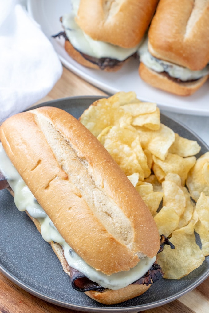 A french Dip Sandwich on a plate with potato chips